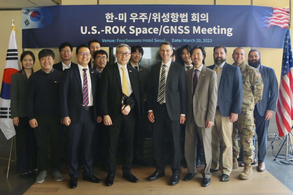 Korean and U.S. delegates pose between the Korean and U.S. flags, with a banner above reading "U.S.-ROK Space/GNSS Meeting"