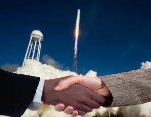 Business handshake with rocket launching in background